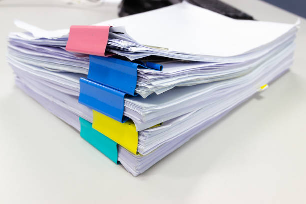 istock Stack of papers documents in archives files with paper clips on desk at offices 1030409082