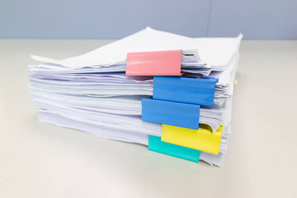 istock Stack of papers documents in archives files with paper clips on desk at offices 1030409294