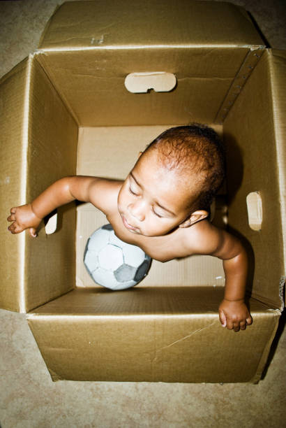 istock Playful Toddler Posing In An Empty Brown Paper Box 1030414182