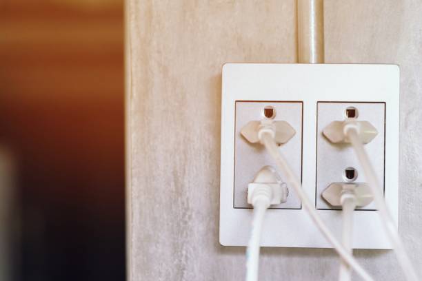 istock White rubber plug power line is electrical plugged into the power outlets gray on the wall loft. with a plug powerline Multiple sockets four channel with connected plugs Electrical wiring metal pipe. 1030419090