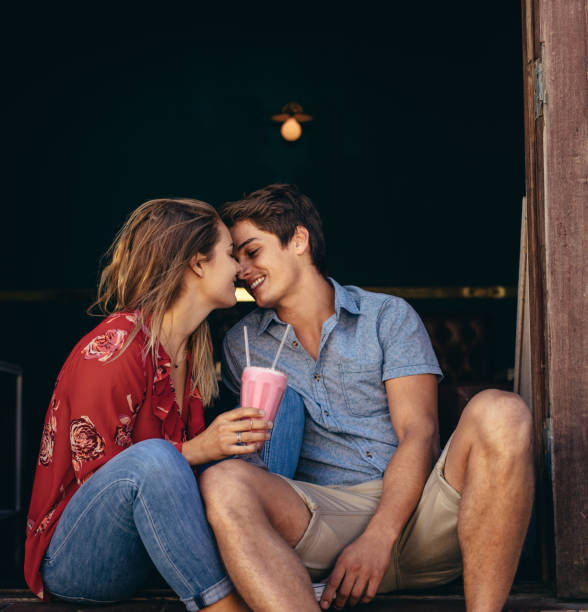 istock Romantic couple sitting together with a milkshake 1030425990