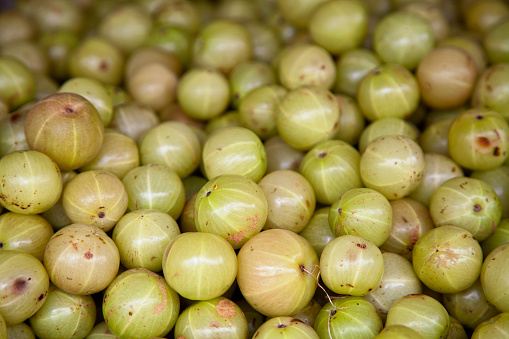 Close-up on a stack of Indian gooseberries on a market stall.