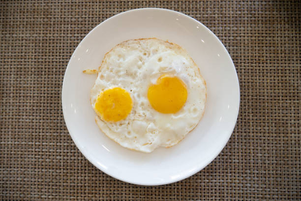 istock Two fresh fried eggs in dish on mat serving for healthy breakfast 1030438294
