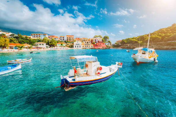 assos dorp op het eiland kefalonia, griekenland. witte boten in de emerald golfde zee water bay - corfu town stockfoto's en -beelden