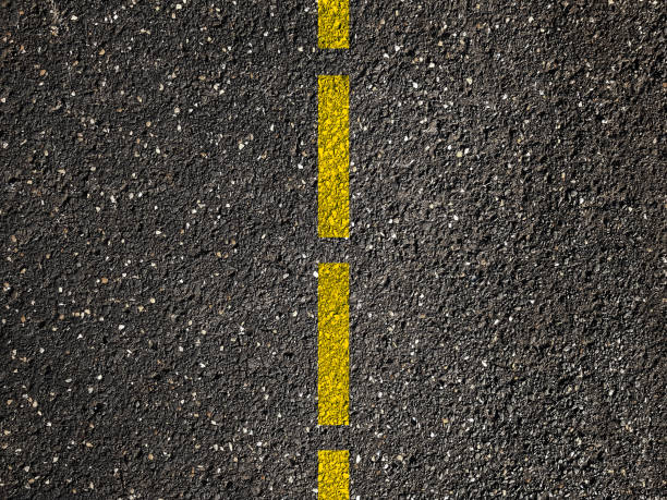 istock Yellow line on asphalt road background 1030451474