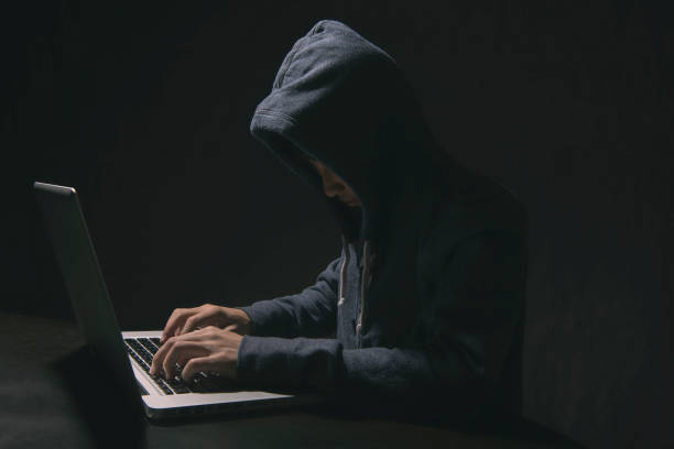 istock hacker in darkness the access to steal information and infect computers and systems. concept of hacking and cyber attack. 1030454944