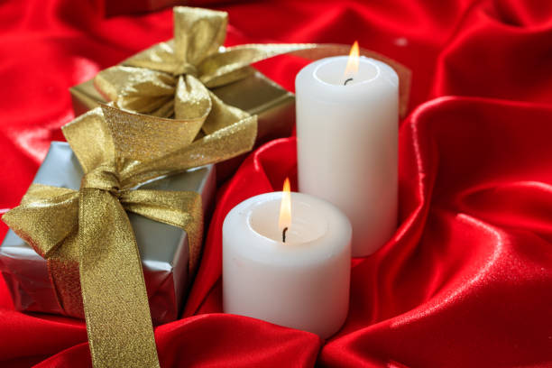 istock Gift boxes and candles on red satin 1030458408