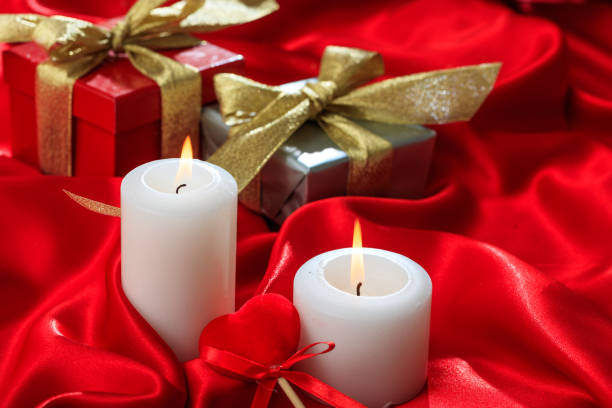 istock Gift boxes and candles on red satin 1030458442