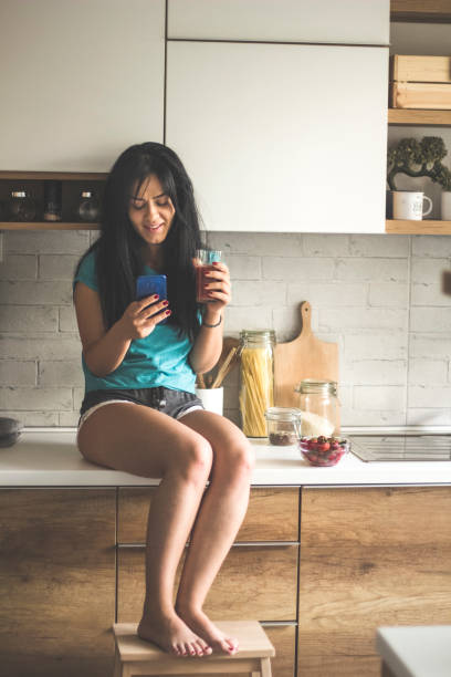 istock Young woman reads her messages while drinking coffee 1030458716
