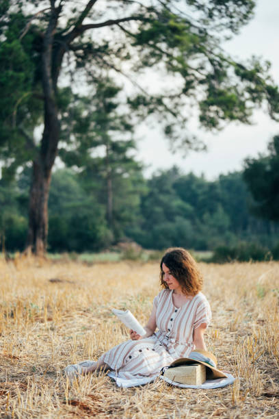 istock Beautiful girl reading in a park 1030470660
