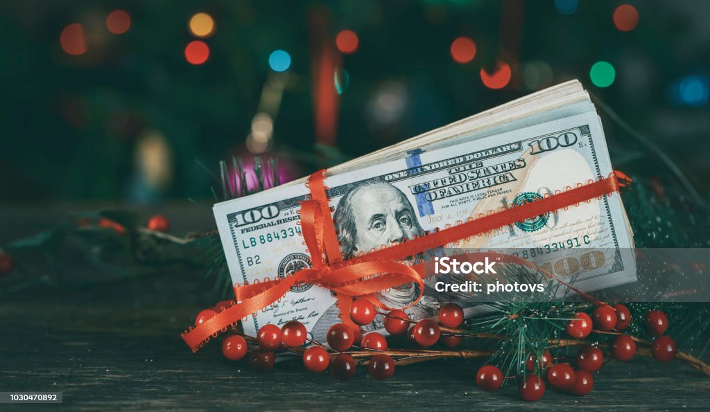 American dollars as a Christmas gif t or a Christmas spending concept American 100 US dolllars as a Christmas gif t or a Christmas spending concept Christmas Stock Photo