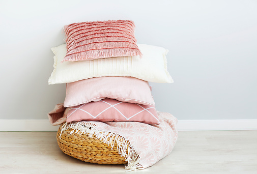Pink and white pillows on the wall background. Close up