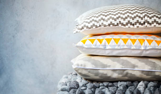 istock Yellow and grey pillows on the wall background 1030474980