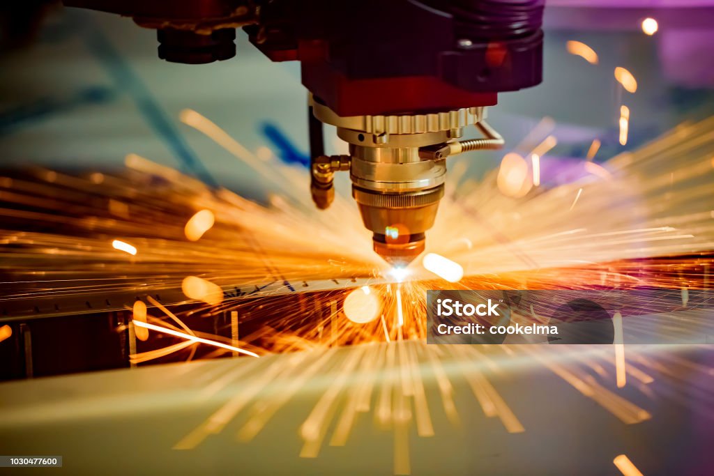 CNC Laser cutting of metal, modern industrial technology. CNC Laser cutting of metal, modern industrial technology. Small depth of field. Warning - authentic shooting in challenging conditions. Manufacturing Stock Photo