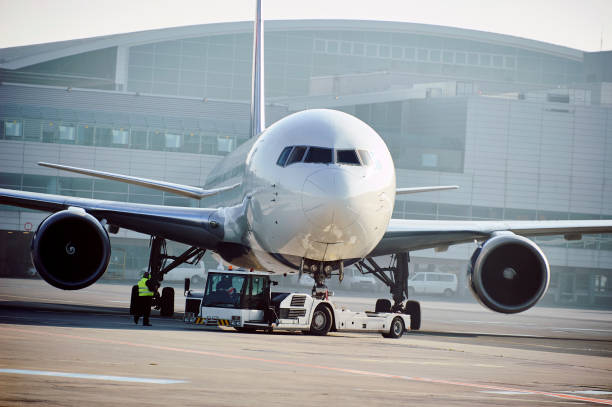 istock Large aircraft being pulled by airport tug tractor 1030479432
