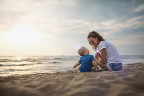 istock Mother playing with baby boy at the beach 1030485242
