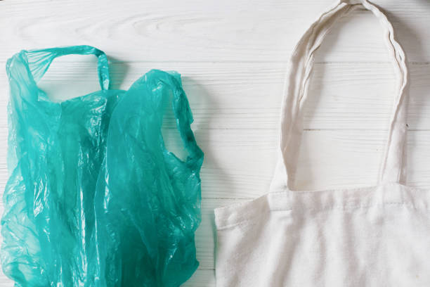 istock ban plastic. plastic bag with eco natural reusable tote bag for shopping, flat lay on rustic background. sustainable lifestyle concept. zero waste. plastic free items. reuse, reduce, refuse, 1030495650