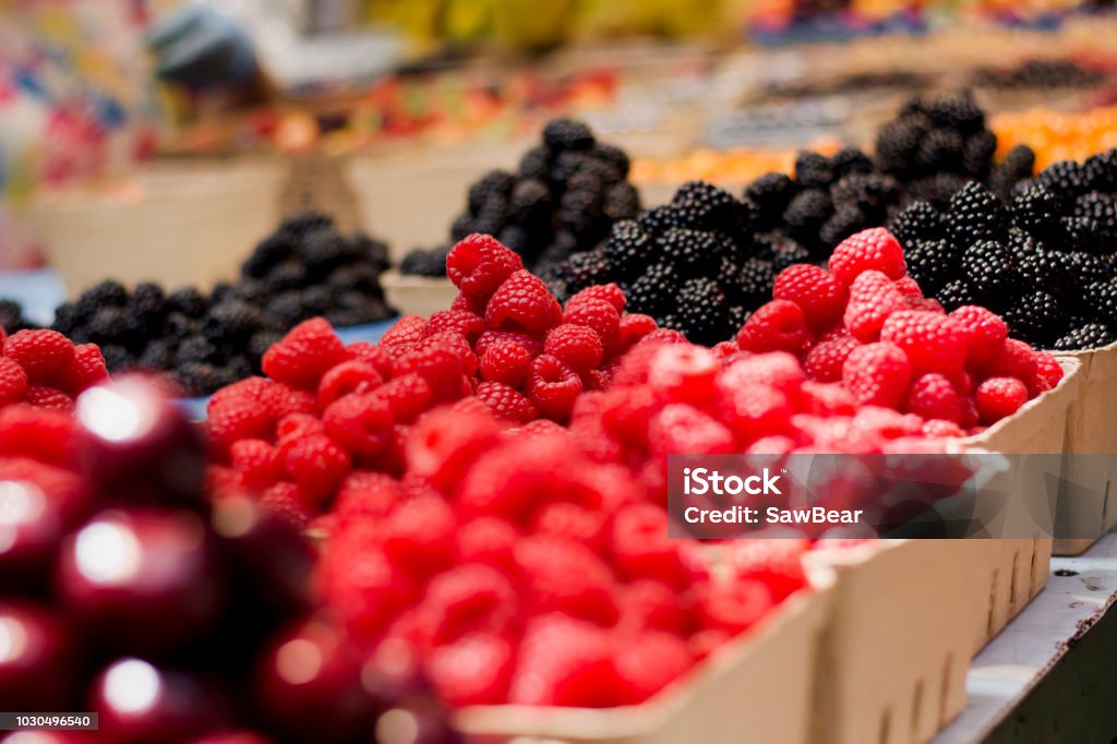 Raspberries Market Display Raspberries and other produce on display in a market. Berry Fruit Stock Photo