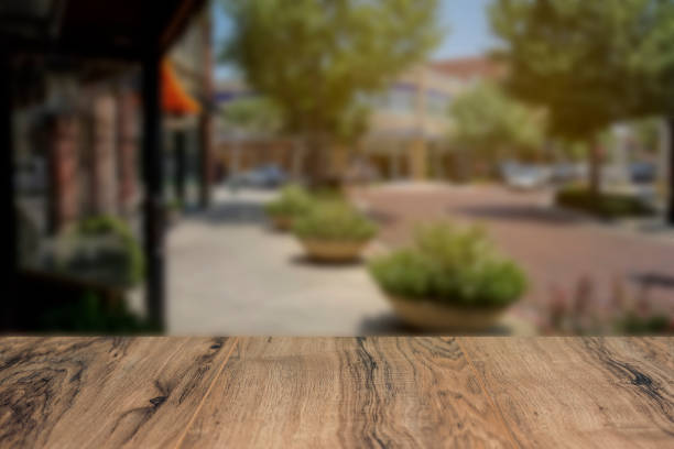 istock City sidewalk with wooden table foreground. 1030503058