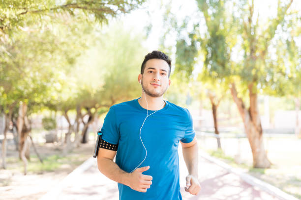 istock Athletic Male Listening Music While Running In Park 1030514438