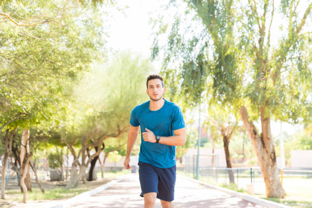 istock Healthy Man Jogging Determinedly On Track In Park 1030515194