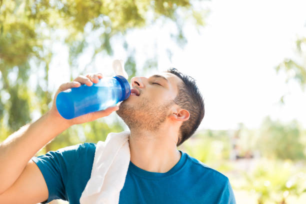 istock Male Athlete Drinking Water After Workout In Park 1030515370