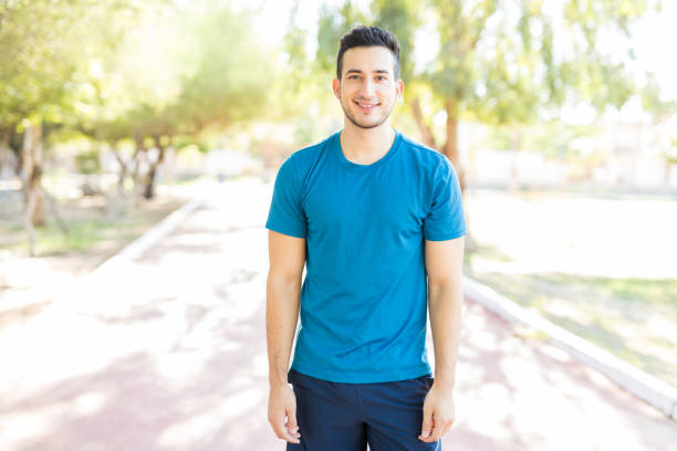 istock Male Athlete Smiling While Standing On Footpath In Park 1030515394