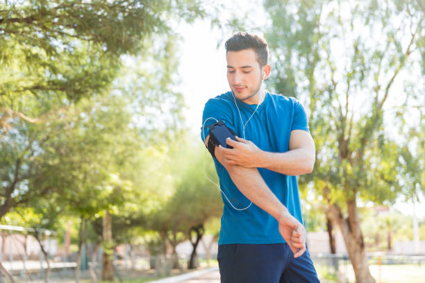 istock Runner Listening Music Through Earphones Using Smartphone In Park 1030515846