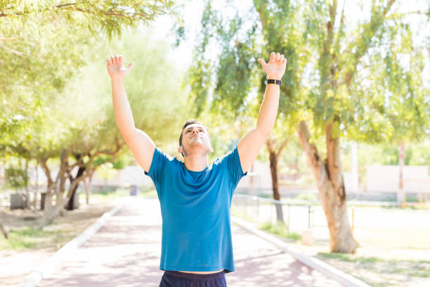 istock Successful Runner Raising Hands To Celebrate At Park 1030518242