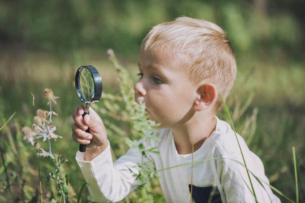istock A small boy explores with a magnifying glass 1030530004