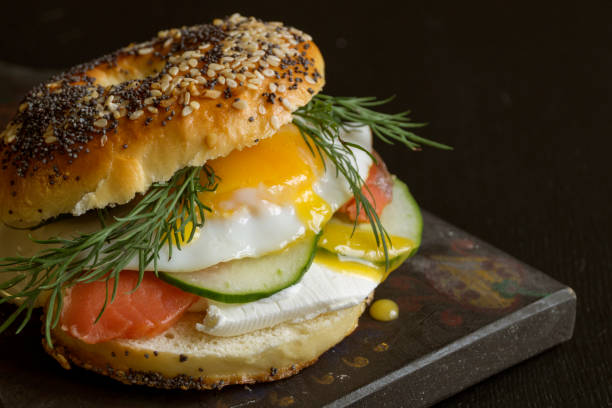 istock bagels with egg and cucumber on black background. 1030530580