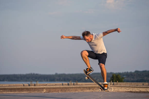 istock Skateboarder doing an ollie trick on background of blue sky. 1030542536