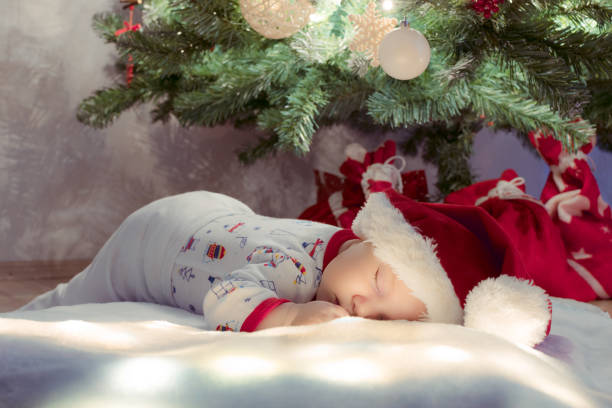 istock Sweet newborn baby boy sleeping and dreaming under Christmas tree. 1030544310