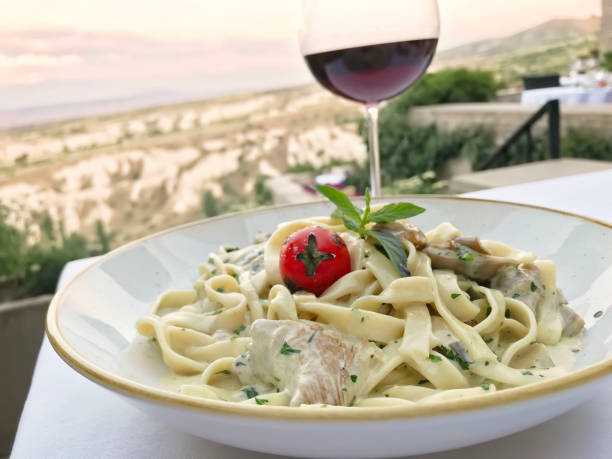 Delicious pasta dish view view Delicious fettuchini pasta dish on a restaurant table large pasta pot stock pictures, royalty-free photos & images