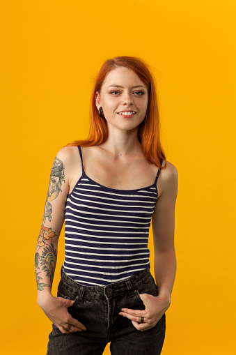 studio portrait of a tattoo artist on a yellow background