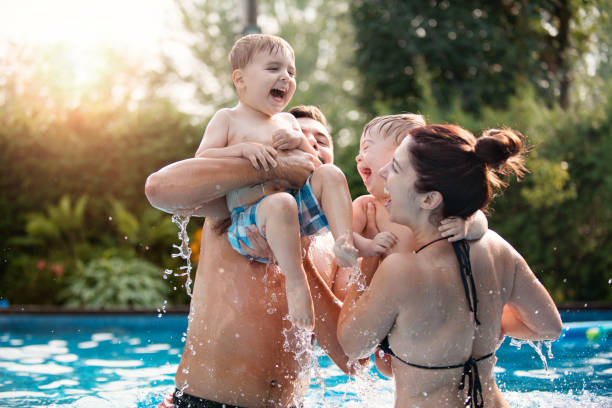 bambino con sindrome di down che si diverte in piscina con la sua famiglia - love enjoyment innocence clothing foto e immagini stock