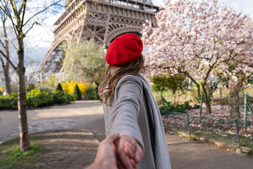 Portrait of a beautiful woman holding hands leading the way to Paris â follow me concepts