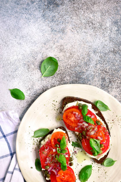 istock Rye toasts with soft cheese, tomato, red onion and capers 1030573228