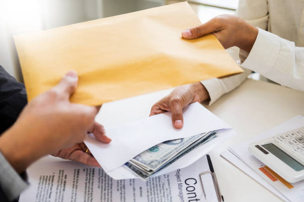 istock Cropped Hands Of People Exchanging Envelope 1030573344