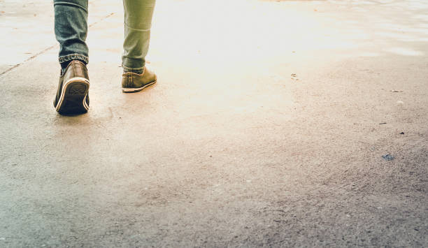istock Low Section Of Man Walking On Road 1030577106