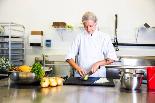 istock A chef in a commercial kitchen using proper technique to safely chop an onion 1030577410