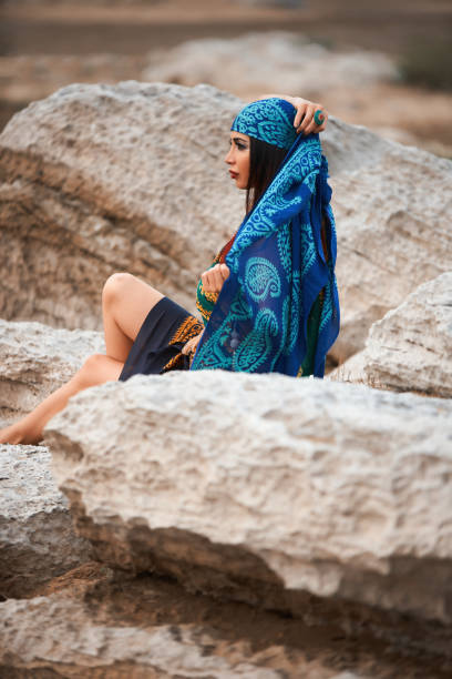 istock Young pretty woman looking on sea, sitting on cliff 1030591420