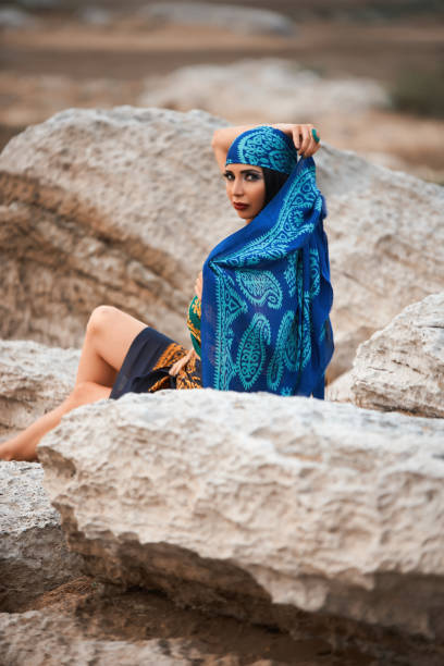 istock Young pretty woman looking on sea, sitting on cliff 1030591486