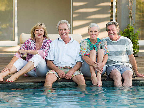 Mature friends by swimming pool  55 59 years photos stock pictures, royalty-free photos & images