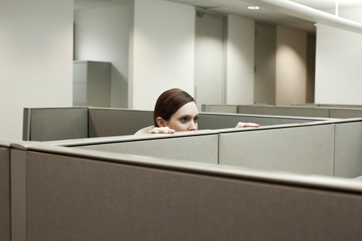 Mujer esconde detrás de cubículo de oficina photo
