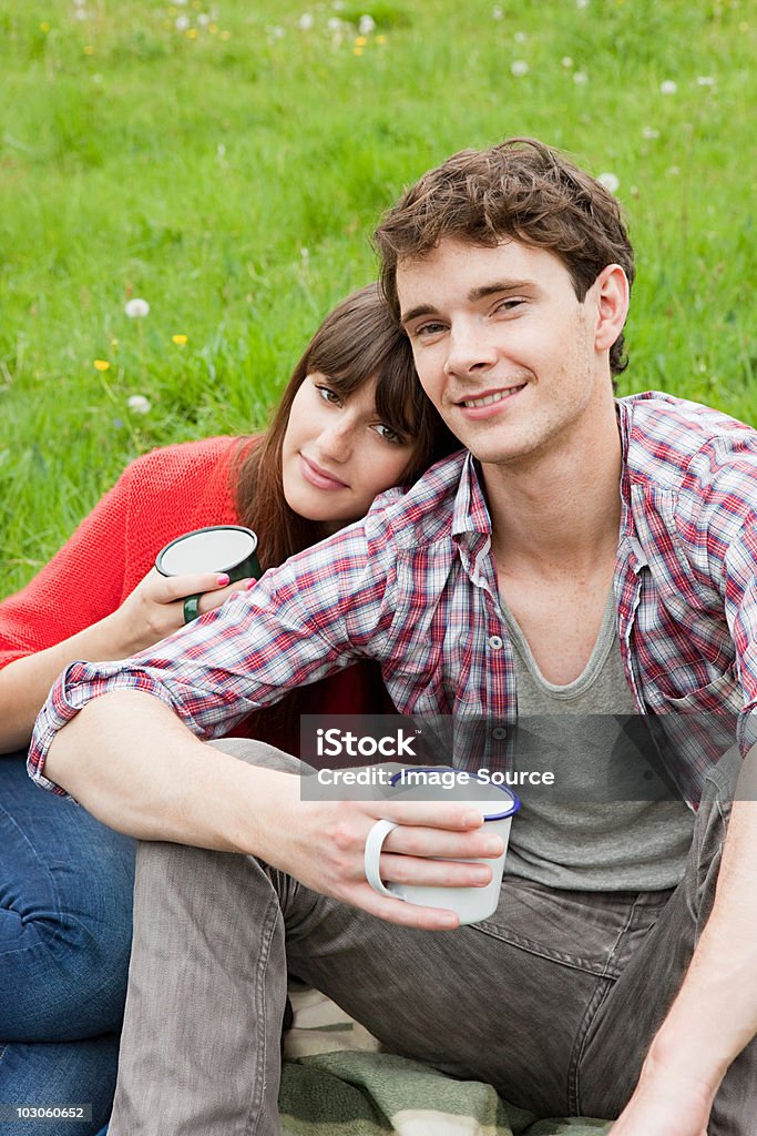 Young couple in field with cups  20-24 Years Stock Photo