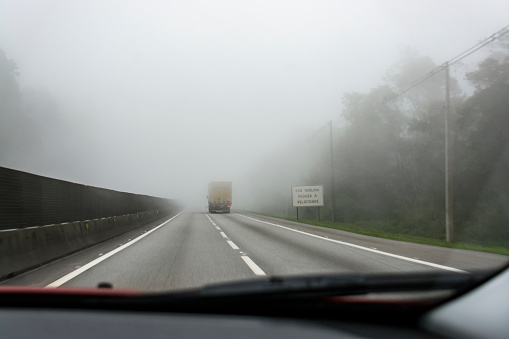 Placa de camión por carretera con niebla y pasando junto al signo 