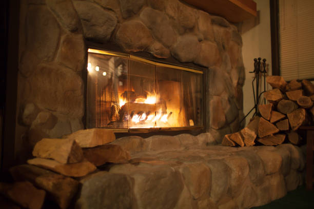 Warm Fireplace Warm Fireplace with wood on the sides brightly lit winter season rock stock pictures, royalty-free photos & images