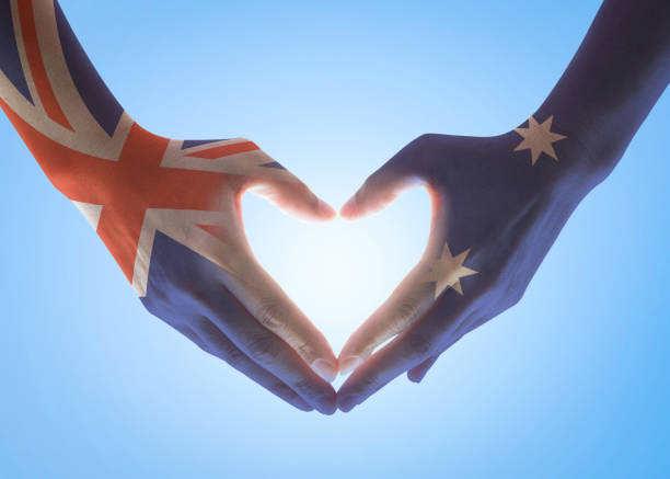 bandera nacional de australia en el pueblo de las manos en forma de corazón aislada sobre fondo de cielo para el día del trabajo y la celebración de la fiesta nacional - australia australia day celebration flag fotografías e imágenes de stock