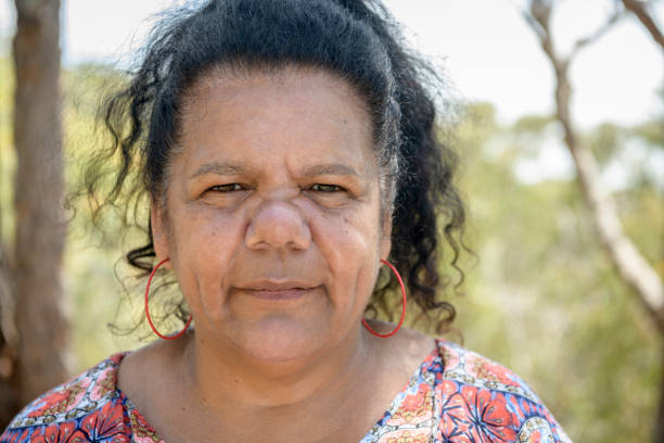 Close up portrait of Australian Aboriginal woman in her 50s Mature woman looking towards camera with serious expression australian culture photos stock pictures, royalty-free photos & images